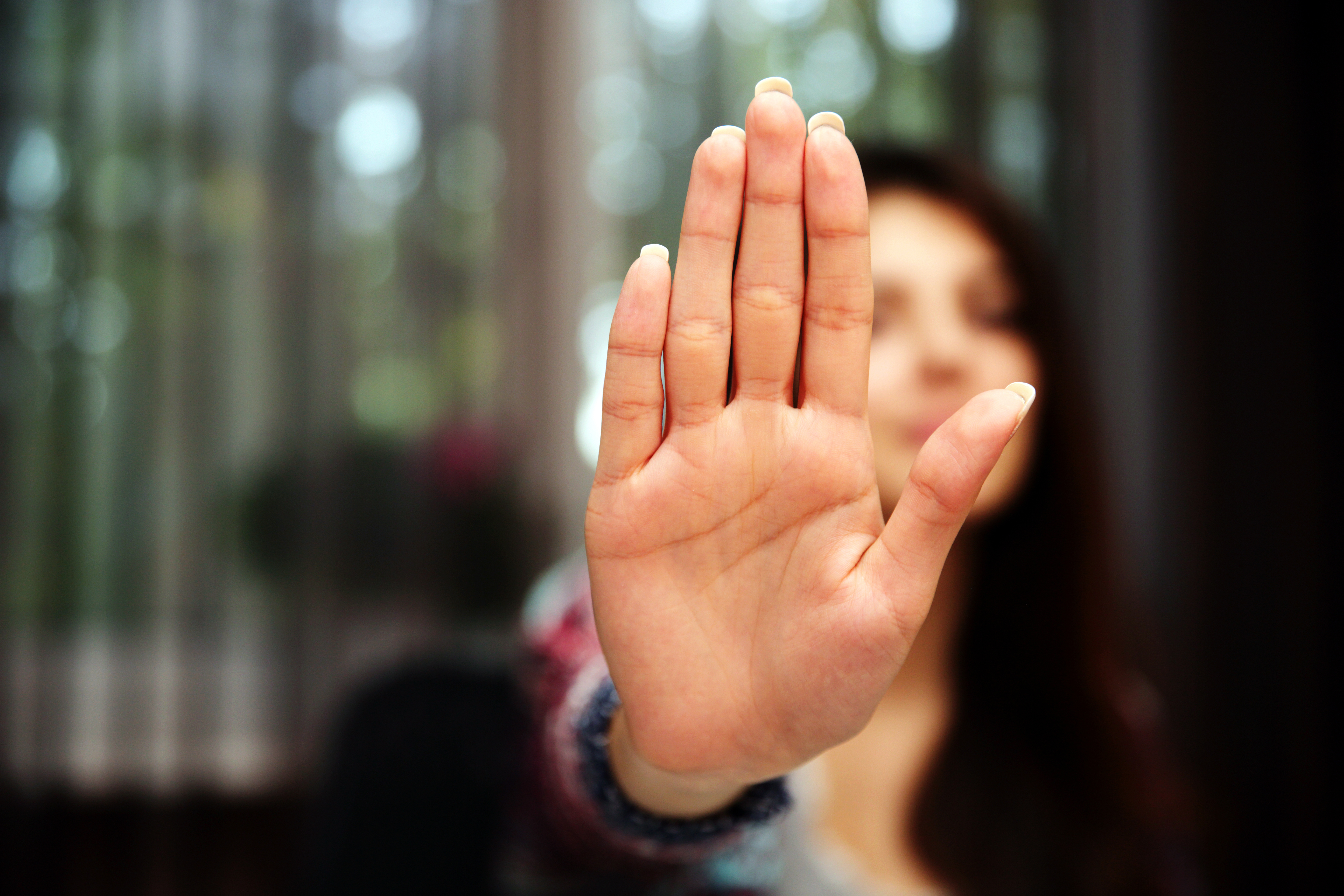 Woman with her hand extended signaling to stop (only her hand is in fo